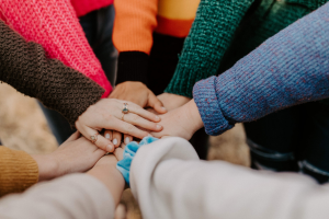 group of people with their hands together in a circle